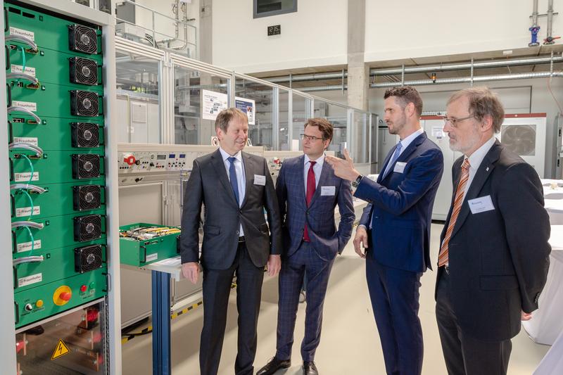 Bereichsleiter Dr. Olivier Stalter (2.v.r.) und die Institutsleiter Prof. Hans-Martin Henning (l.) und Dr. Andreas Bett (r.) erläutern Staatssekretär Andreas Feicht (BMWi) die Ausstattung.