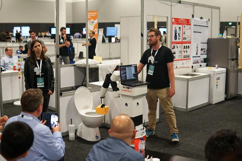 Roboter TIAGo reinigt eine Toilette.