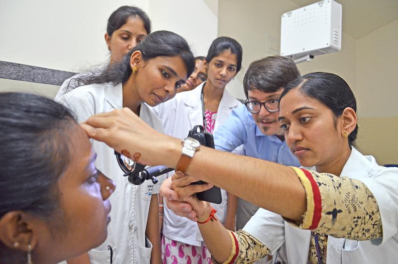 At Sankara Eye Hospital in Bangalore, Dr. Maximilian Wintergerst (center) trains medical assistants in smartphone-based funduscopy