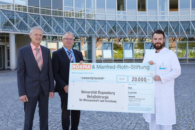 PD Dr. Maximilian Kerschbaum erhält den Förderscheck aus den Händen der Norma-Niederlassungsleiter Anton Gleixner (l.) und Christoph Hegen (2.v.l.).