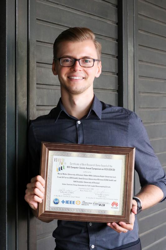 Marcel Walter von der Universität Bremen mit der Urkunde, die er stellvertretend für das Forscherteam auf dem IEEE Computer Society Annual Symposium on VLSI entgegengenommen hat.