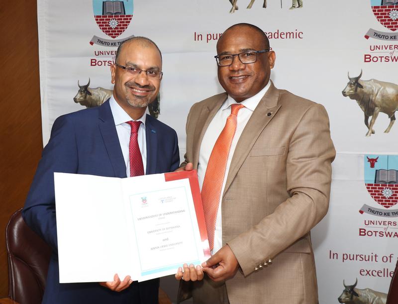 Bild JLU-Präsident Prof. Dr. Joybrato Mukherjee (l.) mit Prof. Dr. David Norris, Vice Chancellor der University of Botswana, mit dem Memorandum of Understanding (MoU) zur engeren Zusammenarbeit. 