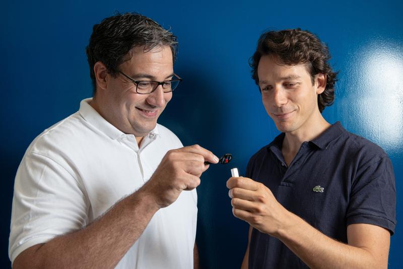 Christian Grünzweig (li.) und Jacopo Valsecchi betrachten einen Magneten, der jenen gleicht, die beispielsweise auch bei Magnetstickern für Kühlschranktüren eingesetzt werden.
