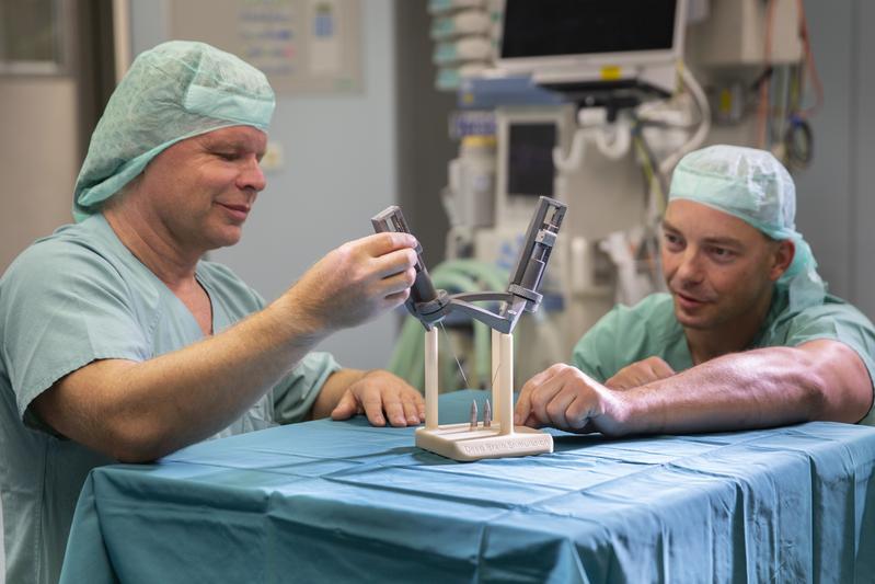 Prof. Dirk Winkler (li.), UKL-Spezialist für funktionelle Neurochirurgie, und Dr. Ronny Grunert, Leiter der Forschungsgruppe, mit einem mittels 3-D-Druck hergestellten Stereotaxie-Rahmen.