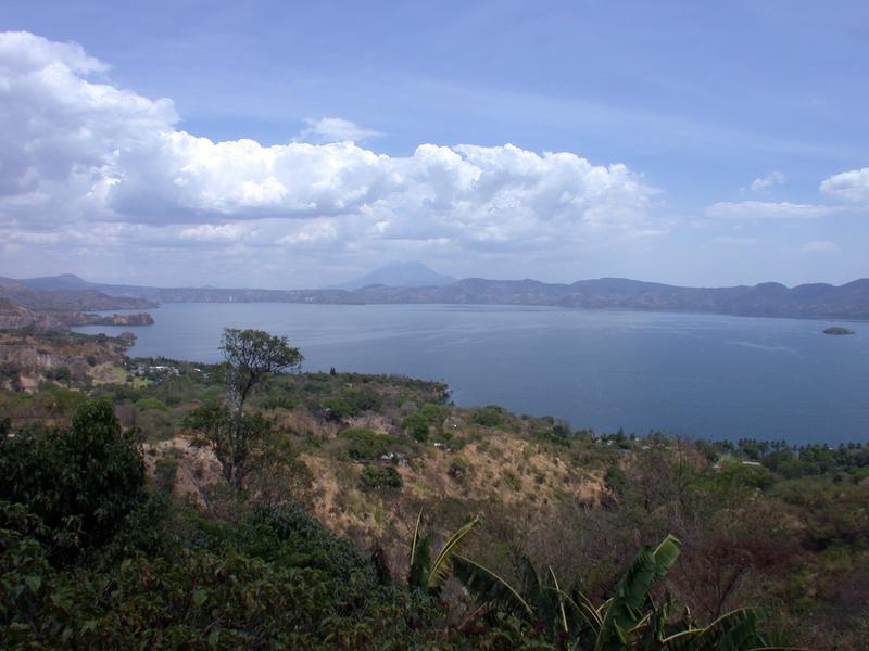  Die Caldera des Ilopango in El Salvador. Im Hintergrund ist der San-Vicente-Stratovulkan zu sehen. Die hellen Ablagerungen im Vordergrund stammen von der Eruption im Jahre 539.