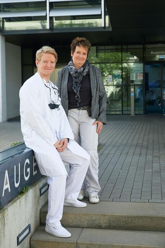 Berit Vogel zusammen mit dem behandelnden Arzt Arne Speidel vor der Augenklinik des Universitätsklinikums Ulm.