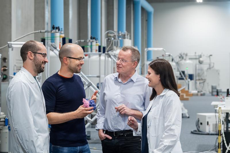 Four members of the research team in the experimental hall of the Bavarian NMR Center (from left to right): Abraham López, Matthias Feige, head of the project, Michael Sattler, and Sina Bohnacker. 