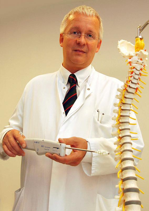 Prof. Dr. med. Jürgen Kiwit, Chefarzt der Neurochirurgen Klinik des HELIOS Klinikums Berlin-Buch, mit dem Modell einer Wirbelsäule. In der Wirbelsäulenchirurgie kann die Strahlenbelastung für die Chirurgen durch das Tragen eines Spezialhandschuhs um 75 Prozent gesenkt werden.