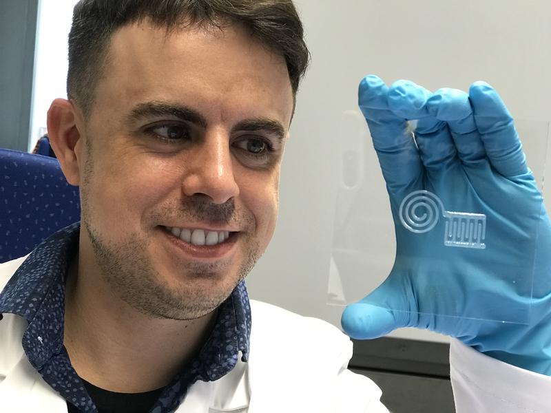 Empa researcher Gilberto Siqueira demonstrates the newly printed nanocellulose circuit. After a subsequent drying, the material can be further processed. 