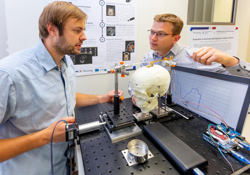 Prof. Markus Seidel (re. im Bild) und der wissenschaftliche Mitarbeiter Marcus Löffler erklären den Versuchsaufbau für die digitale Auswerteeinheit des Hirnspatels. 