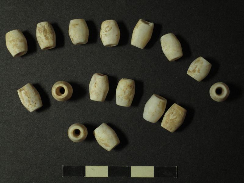 Kalksteinperlen einer Kette, die im Halsbereich der Toten gefunden wurde
