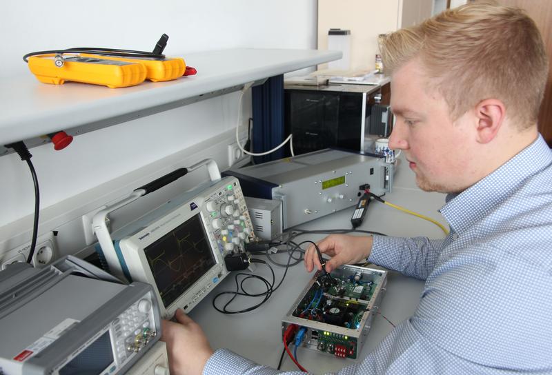  Doktorand Jan Erik Junker untersucht einen Radiofrequenzgenerator, der einen elektrischen Raumfahrtantrieb mit Energie versorgt.