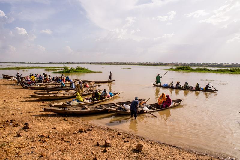 Men ferry people and goods on dugouts on Niger River near Niamey, Niger.