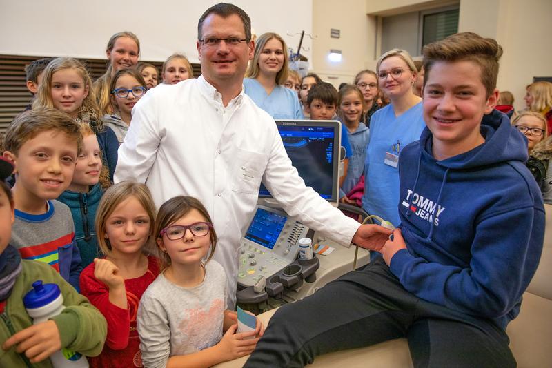 Professor Dr. Lars Pape mit zwei Mitarbeiterinnen und Kindern der KinderUni-Veranstaltung in der MHH