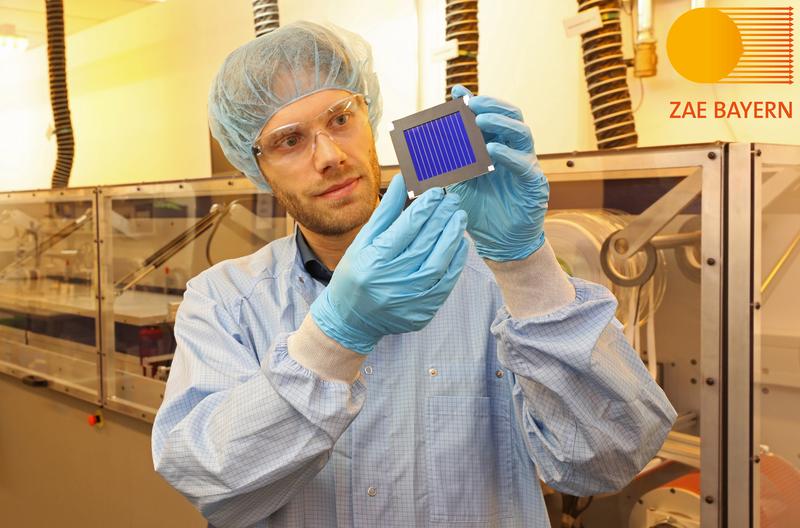 Dr. Andreas Distler (ZAE Bayern) mit dem organischen Rekord-Solarmodul in der Solarfabrik der Zukunft. Im Hintergrund die Pilotlinie für gedruckte Dünnschichtphotovoltaik.(Copyright: ZAE/Kurt Fuchs)