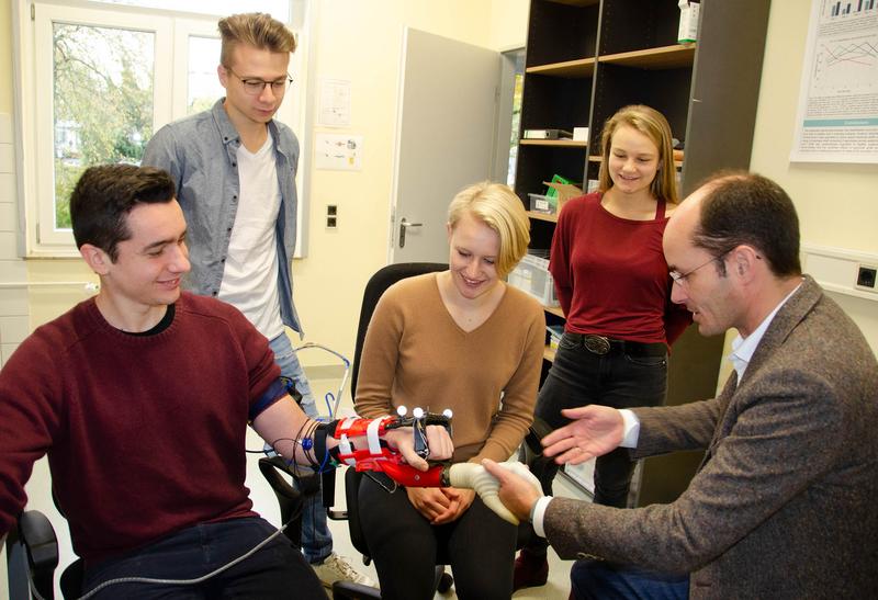 Prof. Dr. med. Arndt Schilling vom ART-Lab (rechts) stellt Studierenden des Studiengangs Mediziningenieurwesen am Gesundheitscampus Göttingen die intuitive Bedienung einer Handprothese vor.