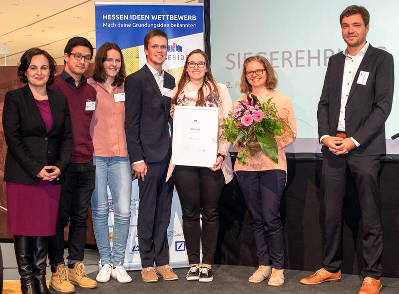 Staatssekretärin Ayse Asar, Tobias Tschang, Sandra Martens, Jonathan Gail, Alisa Schmidt, Sandra Moritz und Jurymitglied Dr. Sebastian Quednau bei der Preisverleihung (v.l.n.r.). 