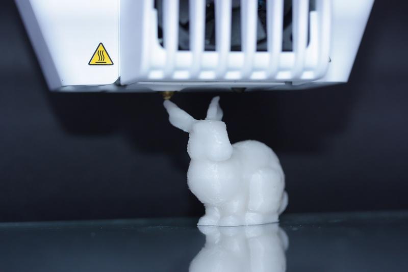 Ein 3D-Drucker druckt einen Kunststoffhasen. Im Kunststoff sind DNA-Moleküle enthalten, in denen die Druckanleitung kodiert ist.