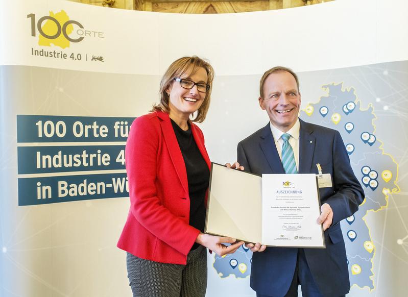 Staatssekretärin Katrin Schütz übergibt am 3. Dezember 2019 die Auszeichnung an den Vertreter des Fraunhofer IOSB, Dr.-Ing. Olaf Sauer.