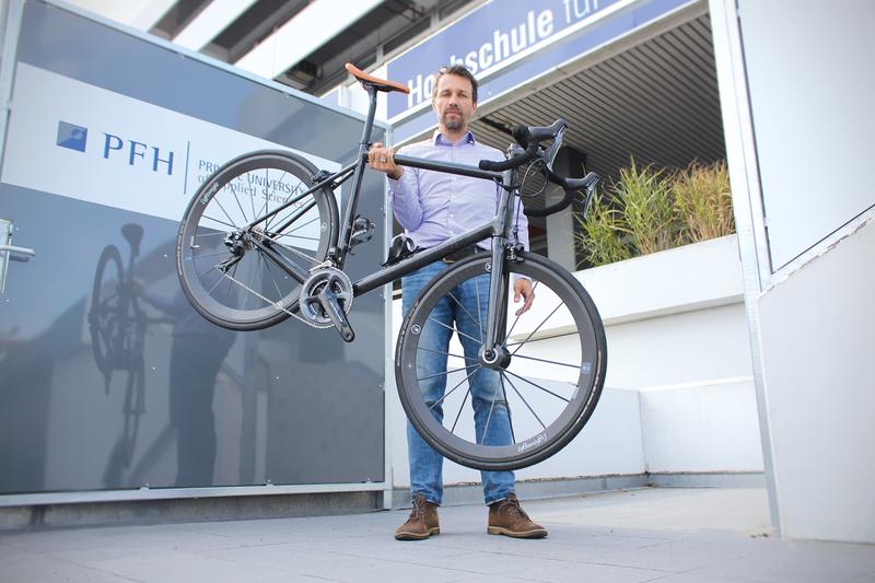 Mit nur einem Arm hochhalten – kein Problem für Prof. Dr. Marc Siebert, der das knapp acht Kilo leichte E-Rennrad entwickelt hat. 
