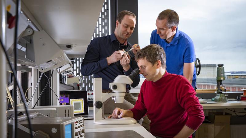 Blick ins Labor - Forscher der TU Chemnitz um Marko Rößler (am Mikroskop) entwickelten einen hocheffizienten Mikrochip zur exakten Positionsbestimmung in Gebäuden.