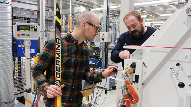 TU-Forscher Matthias Neubert (v. l.) und Florian Tautenhain arbeiten an der Belagextrusion im MERGE Technologiezentrum der TU Chemnitz. 