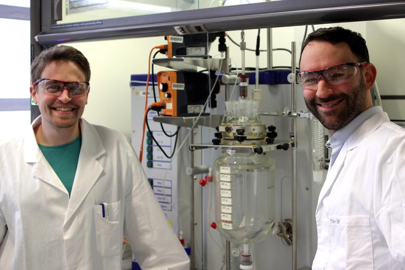 Die beiden Autoren, Paul Stockmann und Dr. Van Opdenbosch, mit dem Reaktor, in dem das polymerisationsfähigen Monomer aus dem Naturstoff 3-Caren hergestellt wurde. 