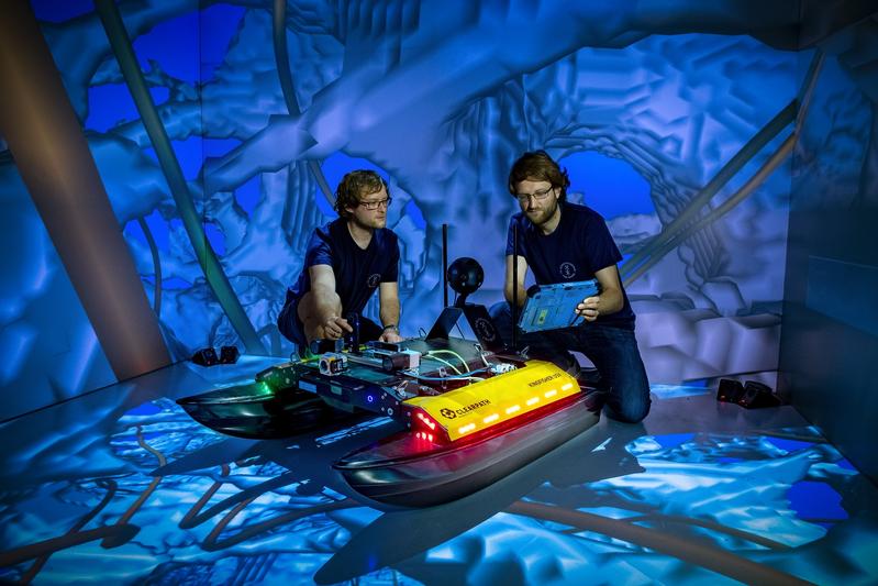 Two computer scientists from Freiberg working on the newly developed swimming robot "Elisabeth" in the CAVE.