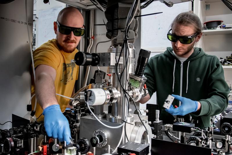 Wissenschafter aus Wien, Kahan Dare (links) und Manuel Reisenbauer (rechts), am Experiment, das ein schwebendes Nanoteilchen in seinen bewegten Quantengrundzustand kühlte. 