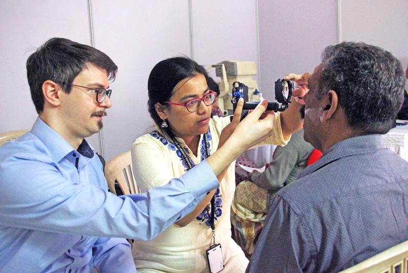 Smartphone-basiertes Augen-Screening in Indien: Geschulte augenärztliche Hilfskraft (re) nutzt ein umgerüstetes Smartphone als Augenspiegel unter Anleitung von Dr. Maximilian Wintergerst (li)