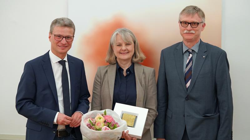 Minister Bernd Sibler (l.) überreichte Professorin Andrea Szczesny die Auszeichnung. Beim Festakt in München war JMU-Kanzler Uwe Klug (r.) dabei.