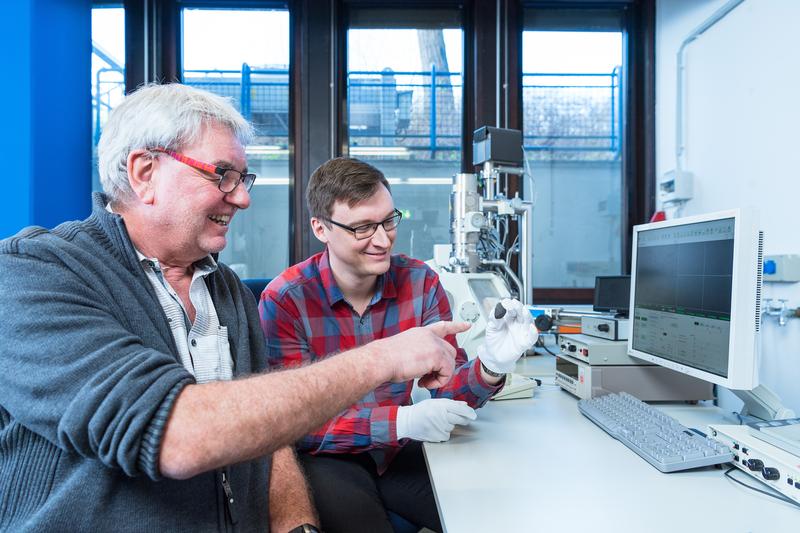 Die Planetologen Prof. Dr. Addi Bischoff (li.) und Markus Patzek mit dem Meteoriten „Flensburg“ vor dem Rasterelektronenmikroskop. 