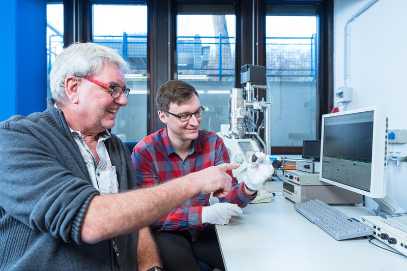 Planetologists Prof. Addi Bischoff (left) and Markus Patzek with the meteorite "Flensburg" in front of the scanning electron microscope. 