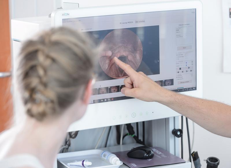 Bei einem phoniatrischen Beratungsgespräch im Interdisziplinären Zentrum für Stimme und Schlucken des Uniklinikums Würzburg werden Endoskopie-Bilder erläutert.