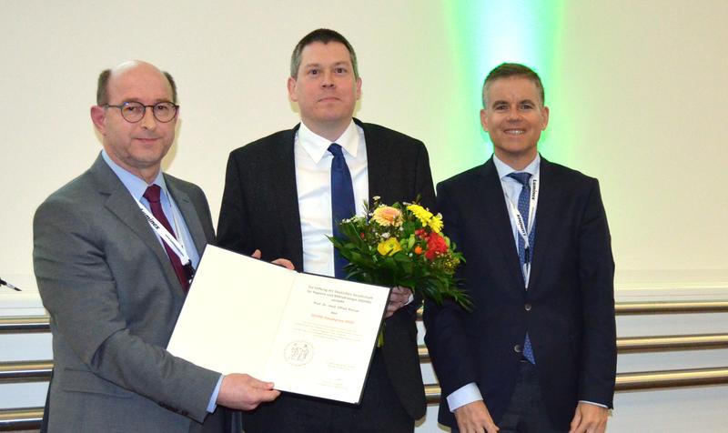 Verleihung des Preises an Professor Oliver Kurzai (Mitte). Links Professor Klaus Pfeffer, Präsident der DGHM-Stiftung, rechts DGHM-Präsident Professor Georg Häcker. 