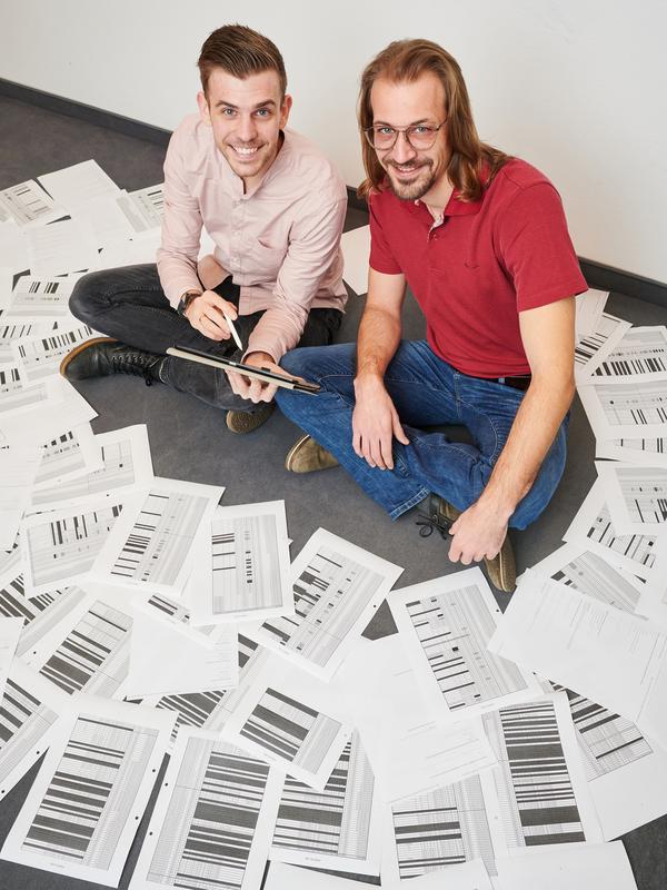 In the midst of many anonymous survey sheets: Dennis Schmiege (left) and Dr. Timo Falkenberg (right) from the University of Bonn. 