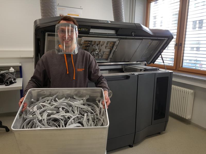 Schutzmasken aus dem 3D-Drucker: Der wissenschaftliche Mitarbeiter Matthias Krause demonstriert, wie die komplette Haube nach dem Zusammenbau in den Kliniken aussehen wird.