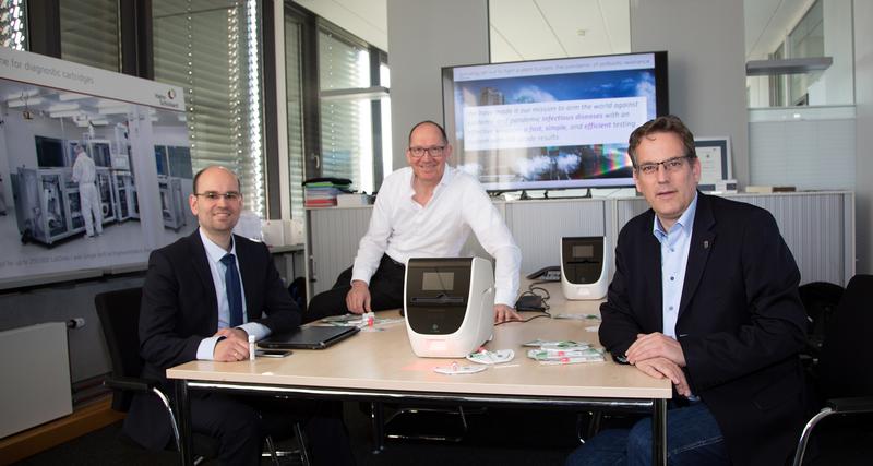 Dr. Daniel Mark (li.) und  Prof. Roland Zengerle führten Prof. Erik Schweickert MdL (re.) das Testsystem vor, für das nun der Corona-Schnelltest weiterentwickelt wird. 