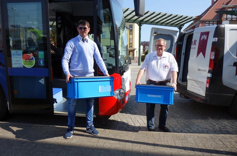 Übergabe an der Bushaltestelle: Bäckermeister Klaus Schreiber (rechts)nimmt die Kisten mit den Eiern entgegen.