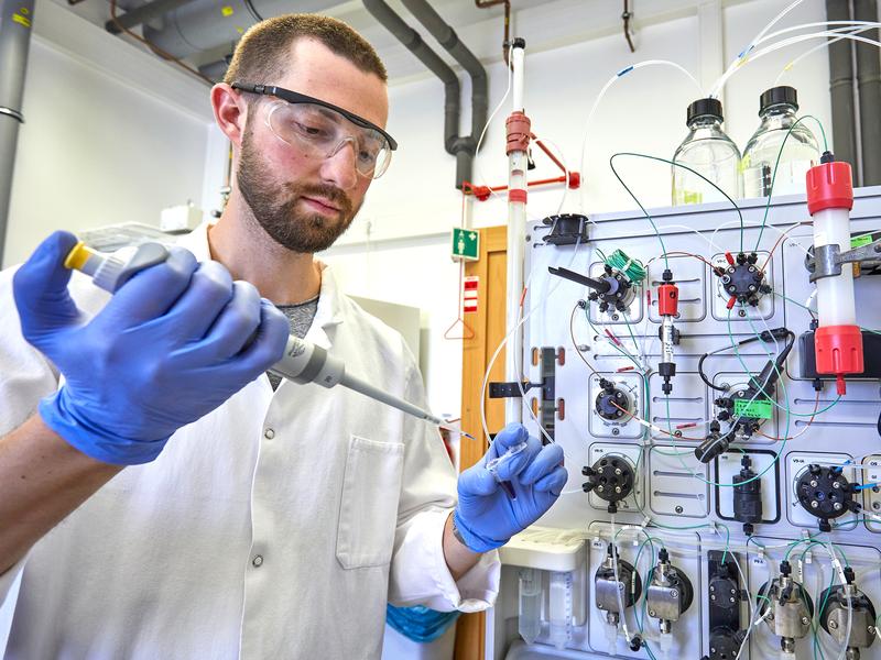 Caspar Heubach beim Pipettieren vor einer Apparatur zur Aufreinigung der markierten Proteine im Labor des Instituts für Physikalische und Theoretische Chemie der Universität Bonn. 