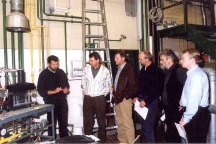 Dipl.-Ing. Thomas Raedler mit einer Gruppe von Teilnehmern vor einem atmosphärischen Gasbrenner, der von Erdgas auf Flüssiggas umgestellt wurde.