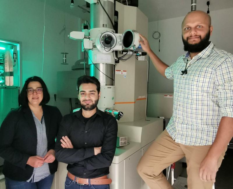 Sie nutzen ausgeklügelte mikroskopische Methoden, um die Grundlage für bessere Batterien zu schaffen (von links): Professorin Dr. Kerstin Volz, Shamail Ahmed und Dr. Anuj Pokle vor dem Raster-Transmissionselektronenmikroskop. 