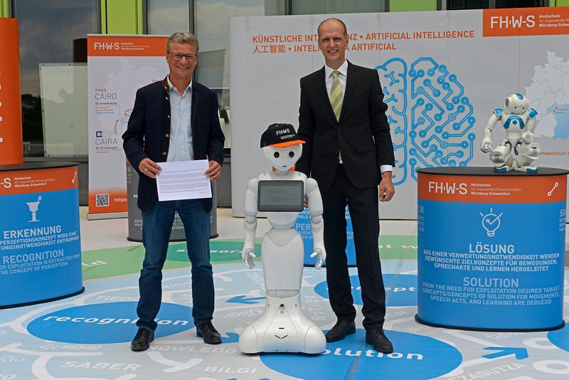 StM Bernd Sibler mit Prof. Dr. Robert Grebner, Präsident der FHWS, bei der Begehung des künstlichen Gehirns der FHWS