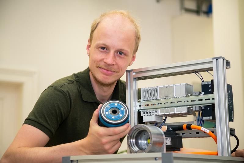 TU Graz PhD student Philipp Eisele with a plastic model (scale 1:1) and the prototype of "Smart Gear" placed in the test stand: Pre-series production is scheduled to start this year.