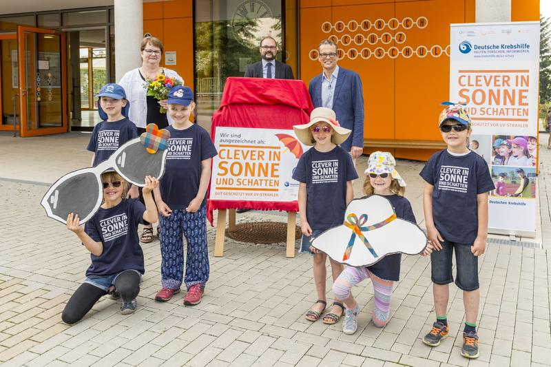 Schüler der 61. Grundschule in Dresden freuen sich zusammen mit dem sächsischen Kultusminister Christian Piwarz (Mitte), Schulleiterin Regine Rogalla und Prof. Martin Bornhäuser (NCT/UCC, Uniklinik Dresden) über die Auszeichnung als Sonnenchecker-Schule. 