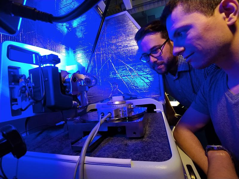 Florian Schäfer (links) und sein Kollege Patrick Grünewald mit einem Hochtemperaturprüfsystem am Rasterkraftmikroskop.