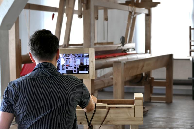 Ein Besucher des Tuchmacher Museums Bramsche lernt das traditionelle Webhandwerk an der interaktiven Webstation „Loom“ kennen, die Studierende der Hochschule Osnabrück entwickelt haben.