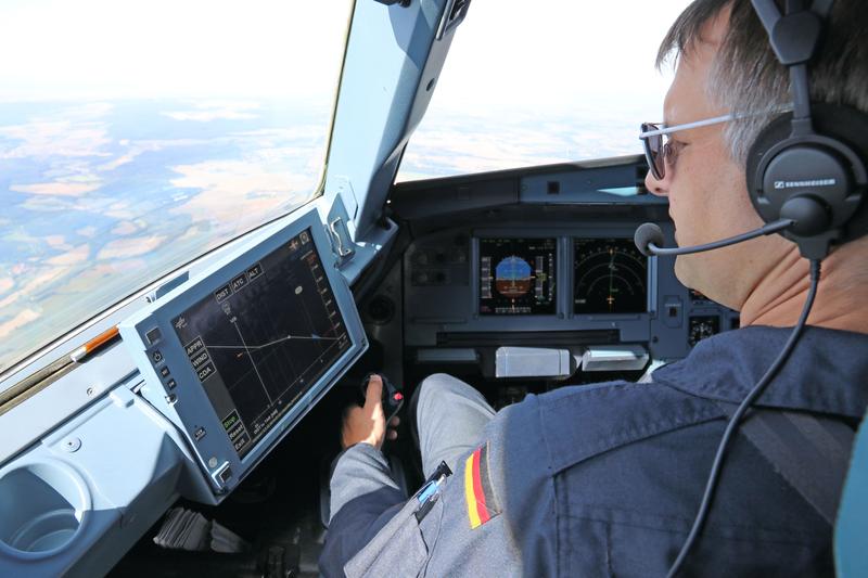 A pilot studies the LNAS display on the flight deck, shortly before initiating the descent.