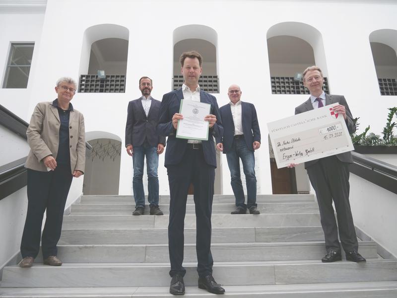 Dr. Markus Elsholz (Mitte) wurde von Univizepräsidentin Ulrike Holzgrabe (links) und Holger Schumacher (Ergon-Verlang, rechts) der Bildungsforschungspreis 2020 verliehen.