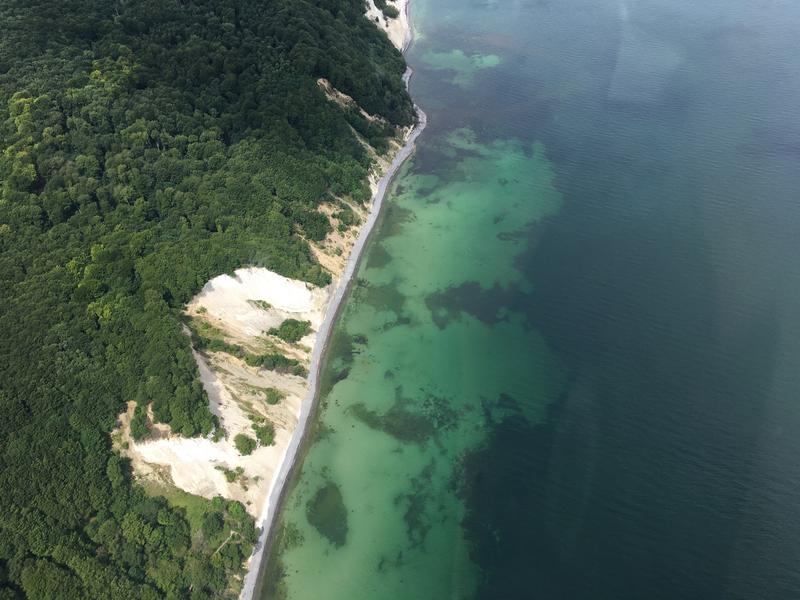 Blick aus dem Flugzeug auf die flachen Küstengewässer der Ostsee: die Kreidefelsen der Møns Klint in Dänemark. 